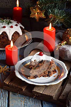 Traditional english Christmas steamed pudding with winter berries, dried fruits, nut in festive setting with Xmas tree and burning