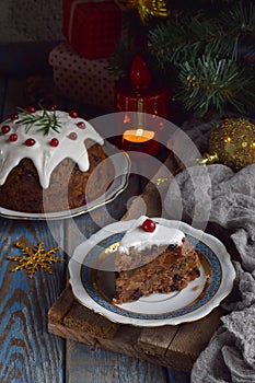 Traditional english Christmas steamed pudding with winter berries, dried fruits, nut in festive setting with Xmas tree and burning