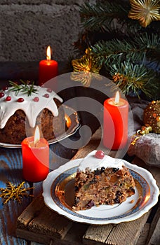 Traditional english Christmas steamed pudding with winter berries, dried fruits, nut in festive setting with Xmas tree and burning