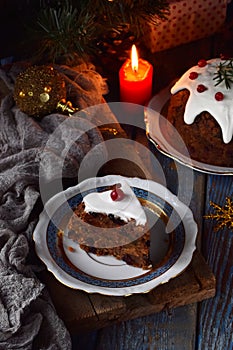 Traditional english Christmas steamed pudding with winter berries, dried fruits, nut in festive setting with Xmas tree and burning