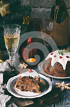 Traditional english Christmas steamed pudding with winter berries, dried fruits, nut in festive setting with Xmas tree and burning