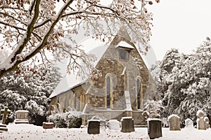 Traditional English village church covered in Snow.