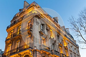 The traditional facade of Parisian building in the evening, France.