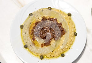 Traditional Fava puree with capers and onions in Santorini taverna, Greece. Fava of Santorini is Protected designation of Origin.