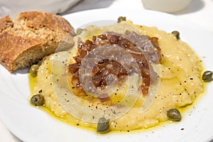 Traditional Fava puree with capers and onions in Santorini taverna, Greece. Fava of Santorini is Protected designation of Origin.