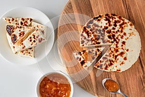 Traditional finnish squeaky cheese with cloudberry jam on wooden cutting board.