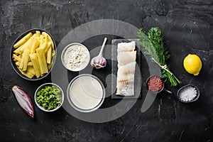 Traditional fish and chips ingredients recipe  raw cod fillets on stone slate  batter, potatoe, tartar sauce, minty mushy peas,