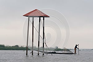 Traditional fisherman on a boat on Inle lake. Leg Rowing Fishermen with net on boat Inle Lake Myanmar Burma