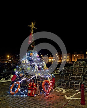 The Traditional Fishermans Christmas Tree lit up at Arbroath Harbour with the Boats and Houses in the background.