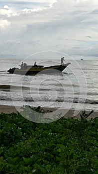 Traditional fishermen start to go fishing. Old wooden fishing boat is cruising out