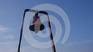 Traditional Fishing bell on quay side in Fife Scotland UK rust red colour blue sky