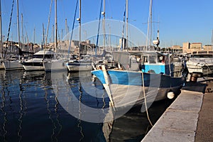 Traditional fishing boat and sailboats in the old port of Marseille, France