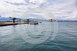 Traditional fishing boats and Bourtzi fortress in the picturesque city of Nafplio former capital of Greece