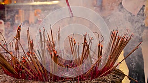 Traditional flames lit incense stick to pray in Buddhist temples flame candle light burning warm light with smoke incense stick.