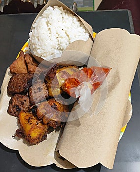 Traditional food from Indonesia, rice white grilled meat fried plantains traditional dish red sauce indonesian cuisine culinary