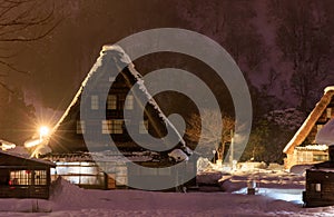 Traditional A-frame house in Gokayama amid snow and mist at night