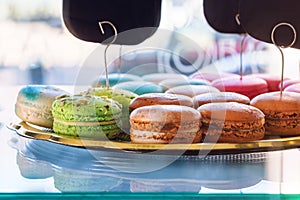 Traditional french colorful macaroons in confectionery shop. Display of delicious pastries in a bakery.