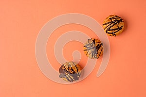 Traditional French dessert. Eclair with chocolate icing. Pastry concept on coral color background. Flat lay or top view.