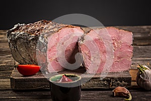 Traditional French Pate en croute with goose meat and liver as closeup on a wooden board. Food recipe background. space for text