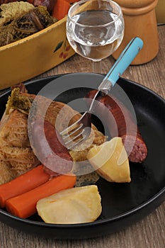 Traditional French winter meal with smoked pork sausages and vegetables