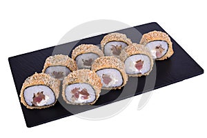 Traditional fresh japanese sushi on black stone Theca warm roll on a white background. Roll ingredients: tuna, philadelphia cheese
