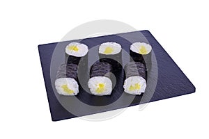 Traditional fresh japanese sushi maki on black stone Maki Daikon on a white background. Roll ingredients: radish daikon, nori,