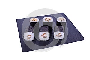 Traditional fresh japanese sushi maki on black stone Maki Unagi on a white background. Roll ingredients: eel, unagi sauce, nori,