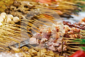 Traditional fried chinese food on sticks at night street vendor market