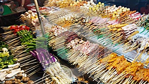 Traditional fried chinese food on sticks at street vendor market