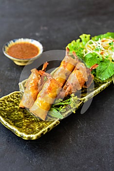 Traditional fried vietnamese spring rolls with pork, shrimp, rice paper on black background side view