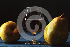 Traditional fruit brandy and pears on a vintage grunge wooden ba