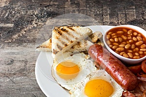 Traditional full English breakfast with fried eggs, sausages, beans, mushrooms, grilled tomatoes and bacon