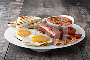 Traditional full English breakfast with fried eggs, sausages, beans, mushrooms, grilled tomatoes and bacon