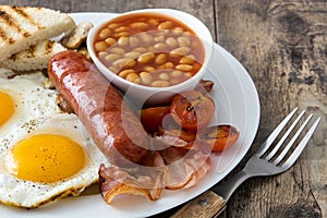 Traditional full English breakfast with fried eggs, sausages, beans, mushrooms, grilled tomatoes and bacon