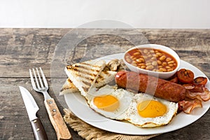 Traditional full English breakfast with fried eggs, sausages, beans, mushrooms, grilled tomatoes and bacon