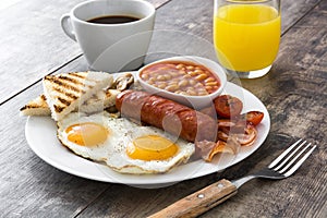 Traditional full English breakfast with fried eggs, sausages, beans, mushrooms, grilled tomatoes and bacon