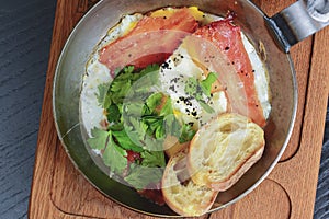 Traditional Full English Breakfast. Sunny-side-up fried eggs, sausages, beans, mushrooms and bacon in a frying pan