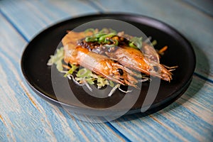 Traditional gambas a la plancha or grilled shrimp with garlic and pepper in black plate photo