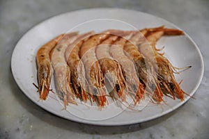 Traditional gambas a la plancha or grilled shrimp tapas being cooked on a hot plate in Madrid, Spain photo