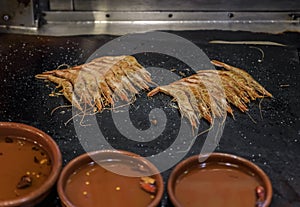 Traditional gambas a la plancha or grilled shrimp tapas being cooked on a hot plate in Madrid, Spain photo