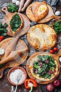 Traditional Georgian adjara khachapuri and Kolkh khachapuri on the table. Homemade baking. Top view. Flat lay