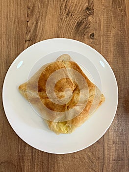 Traditional Georgian Adjara Khachapuri on white plate on wooden table