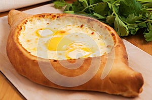 Traditional Georgian cuisine. Ajara khachapuri on a wooden Board