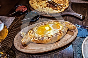 Traditional Georgian cuisine. Ajara khachapuri on a wooden Board