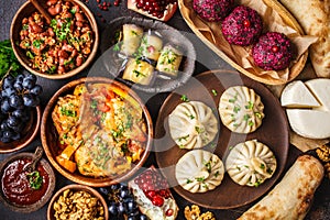 Traditional Georgian cuisine background. Khinkali, phali, chahokhbili, lobio, cheese, eggplant rolls, dark background