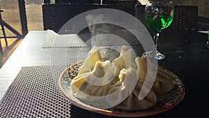 Traditional Georgian dish, khinkali Kalakuri, on a wooden table served with green with Tarkhun georgian limonade