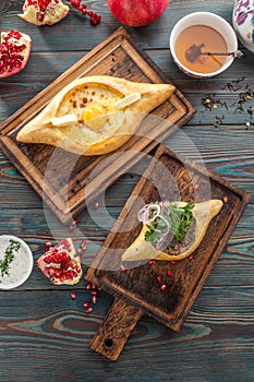 Traditional Georgian khachapuri bread with cheese and meat on wooden table