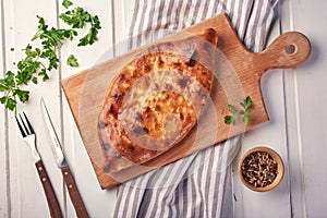 Traditional georgian Khachapuri with spices on wooden table
