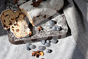 Traditional German Christstollen, winter holiday bakery. Bread or cake with raisins, blueberry and sugar powder. Stollen