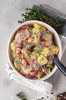 Traditional German potato salad with cucumber, onion and bacon prepared in Swabian-Style Southern Germany.